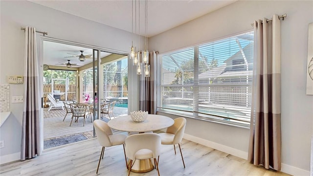 dining room featuring a healthy amount of sunlight, light hardwood / wood-style flooring, and a notable chandelier