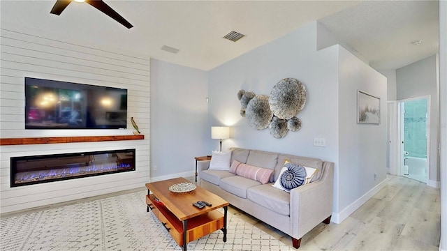 living room featuring ceiling fan and light hardwood / wood-style floors