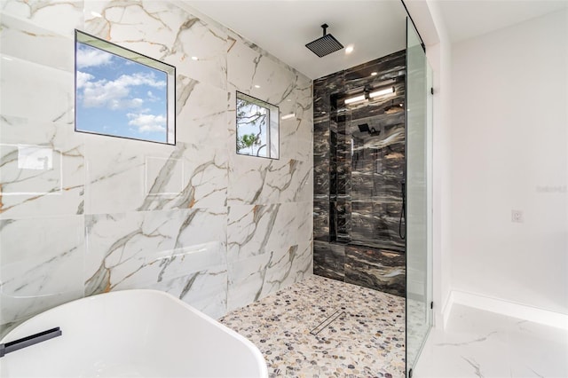 full bath featuring a soaking tub, a tile shower, marble finish floor, and baseboards