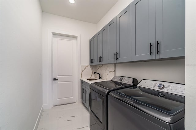 laundry room with cabinets, washing machine and clothes dryer, sink, and light tile patterned floors