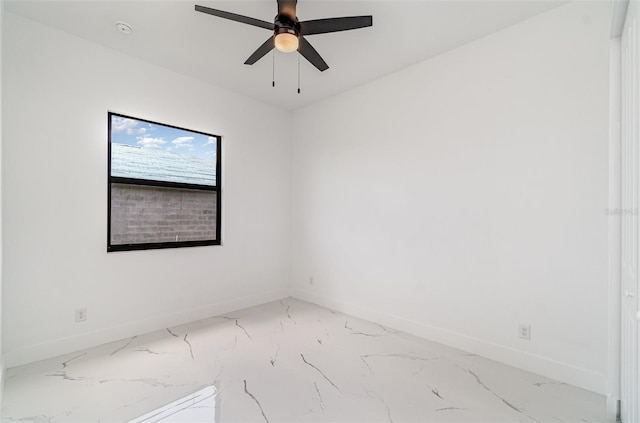 spare room with a ceiling fan and baseboards