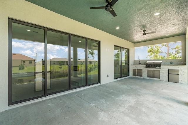 view of patio / terrace featuring ceiling fan, exterior kitchen, and grilling area