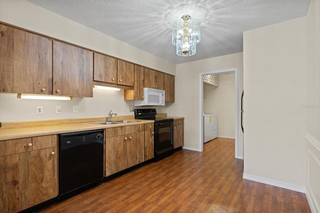 kitchen with sink, dark hardwood / wood-style floors, black appliances, and a textured ceiling