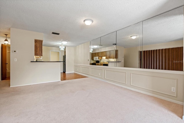 unfurnished living room with carpet floors and a textured ceiling