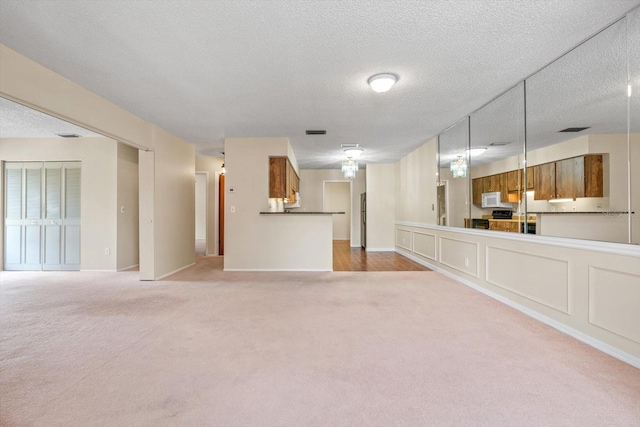 unfurnished living room with carpet floors and a textured ceiling