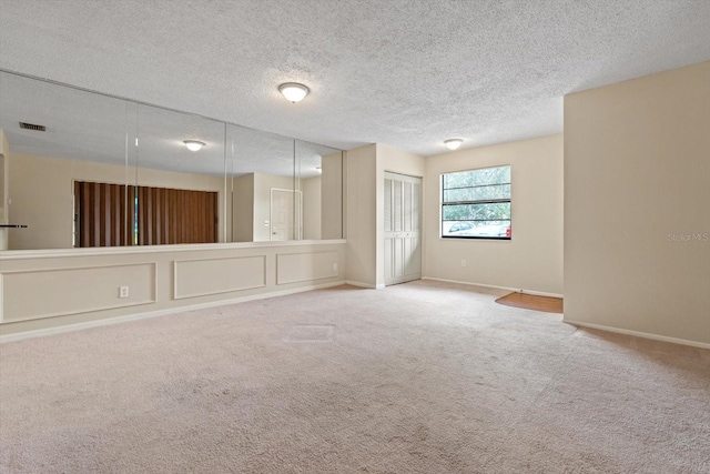 unfurnished room featuring a textured ceiling and carpet flooring