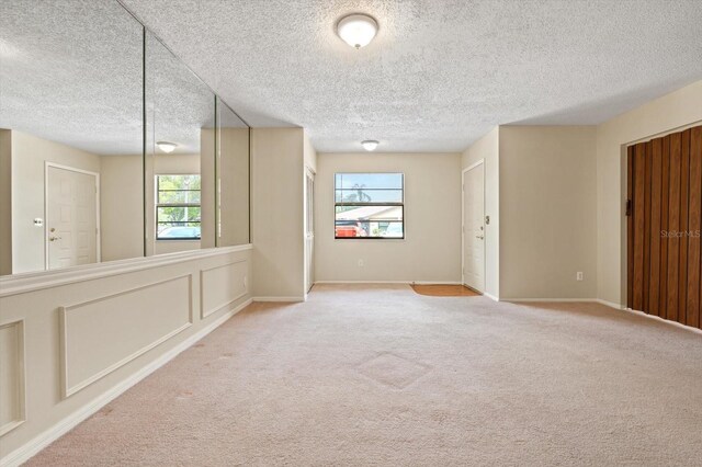 carpeted spare room featuring a textured ceiling