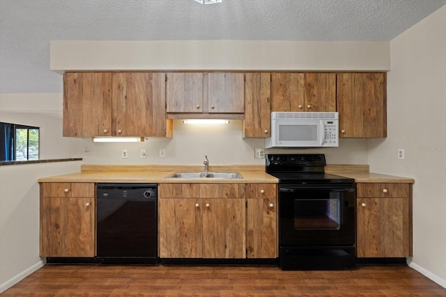 kitchen with sink, black appliances, a textured ceiling, and dark hardwood / wood-style floors