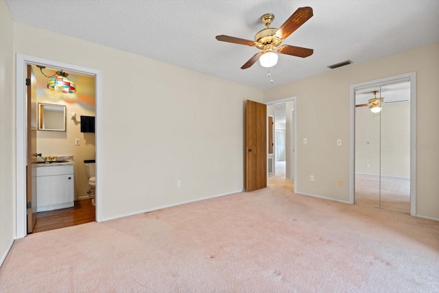 unfurnished bedroom featuring hardwood / wood-style flooring, a closet, sink, and ceiling fan