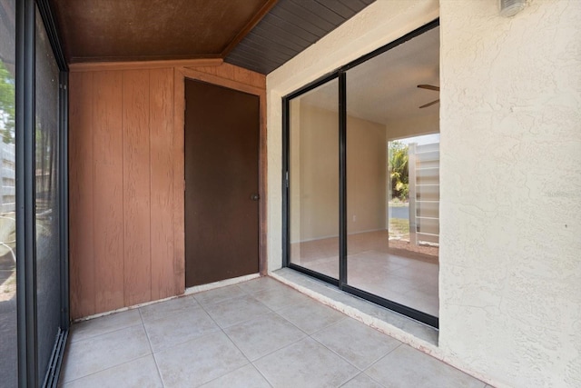 unfurnished sunroom featuring wooden ceiling, ceiling fan, and vaulted ceiling