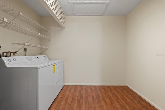 clothes washing area with hardwood / wood-style flooring and independent washer and dryer