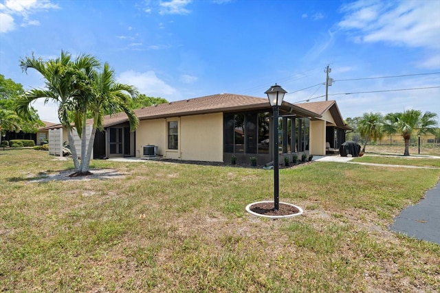 back of house featuring central AC and a yard