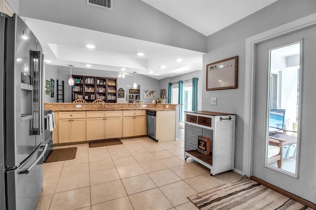 kitchen with appliances with stainless steel finishes, kitchen peninsula, hanging light fixtures, and light tile patterned floors