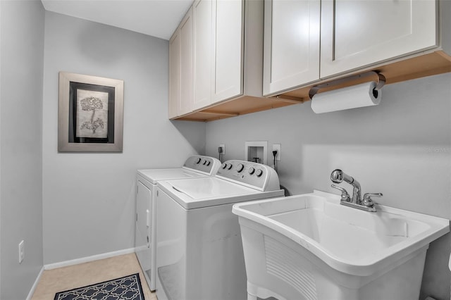 clothes washing area with cabinets, sink, and washing machine and clothes dryer