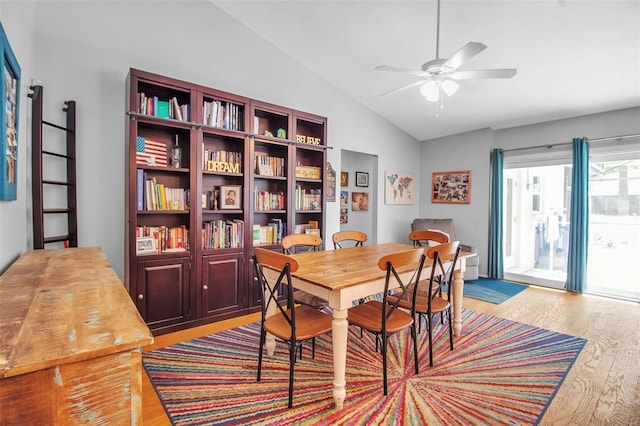 dining room with ceiling fan, vaulted ceiling, and light wood-type flooring