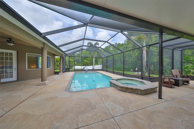 view of swimming pool with an in ground hot tub, glass enclosure, and a patio area