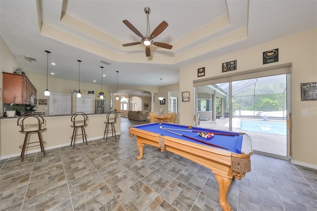 recreation room featuring a raised ceiling, ceiling fan, plenty of natural light, and billiards