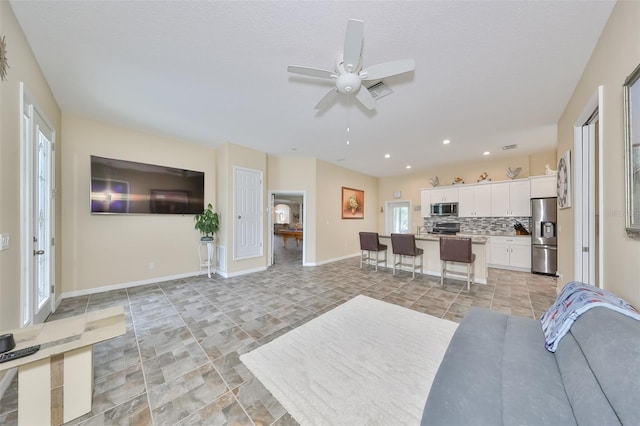 living room featuring a textured ceiling and ceiling fan