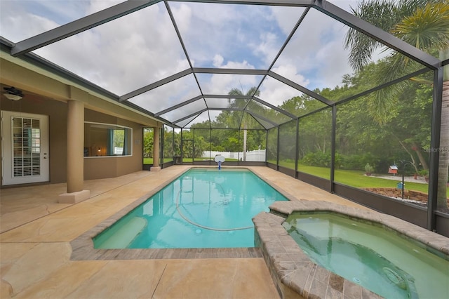 view of swimming pool featuring glass enclosure, an in ground hot tub, and a patio