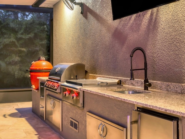 view of patio with sink, an outdoor kitchen, and a grill