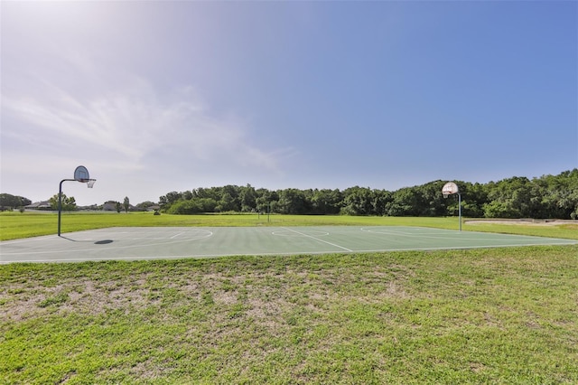 view of sport court with a lawn