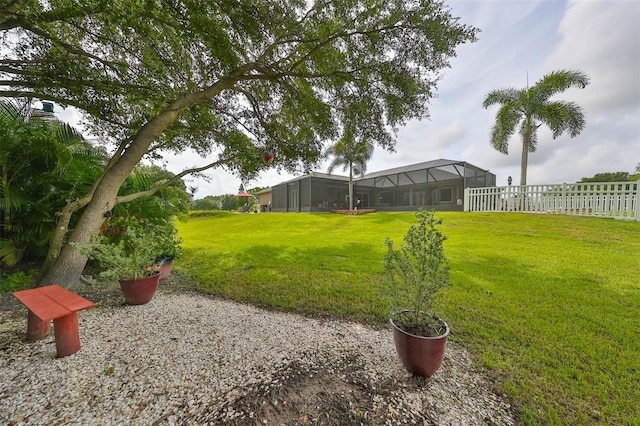 view of yard with fence and glass enclosure