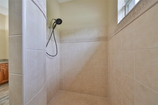 full bath featuring vanity and tiled shower