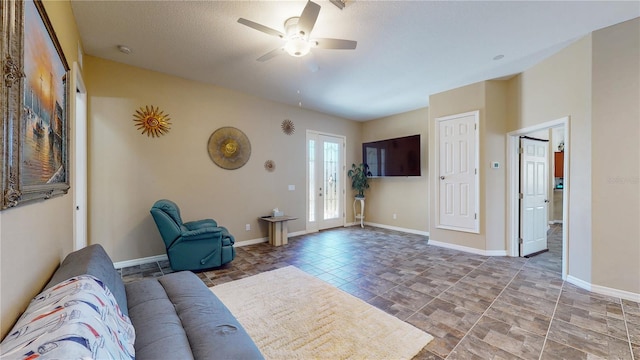 living room featuring baseboards and ceiling fan
