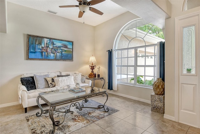 tiled living room featuring a textured ceiling, a wealth of natural light, and ceiling fan