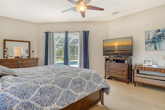 bedroom with light hardwood / wood-style flooring, a textured ceiling, and ceiling fan