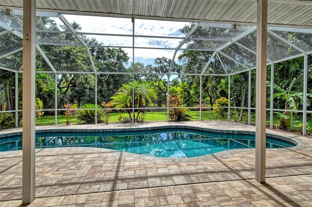 view of pool featuring glass enclosure and a patio area