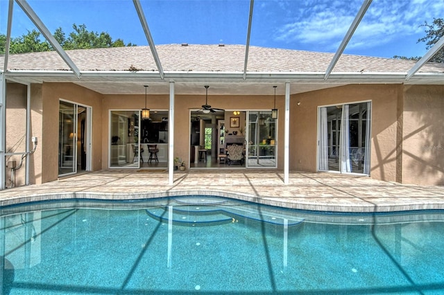 view of swimming pool featuring glass enclosure, a patio area, and ceiling fan