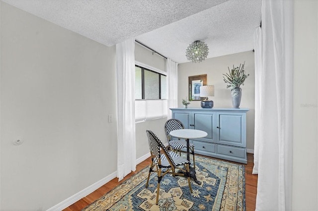 living area with hardwood / wood-style flooring and a textured ceiling