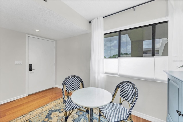 dining room featuring a textured ceiling and hardwood / wood-style flooring