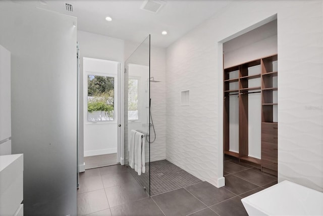 bathroom featuring tiled shower and tile patterned flooring