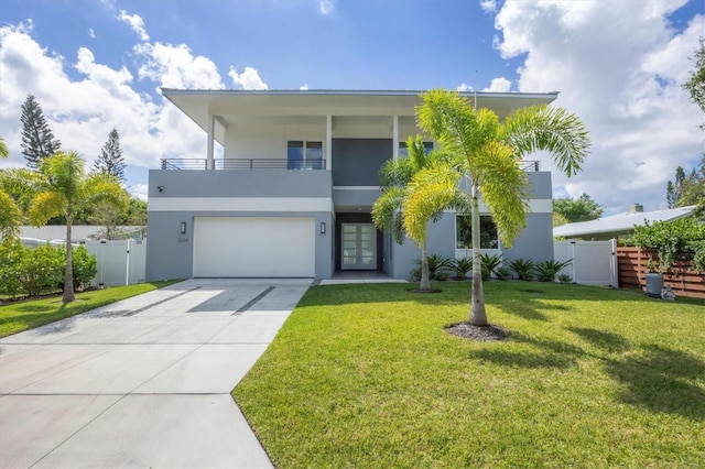 view of front facade with a balcony, a front yard, and a garage