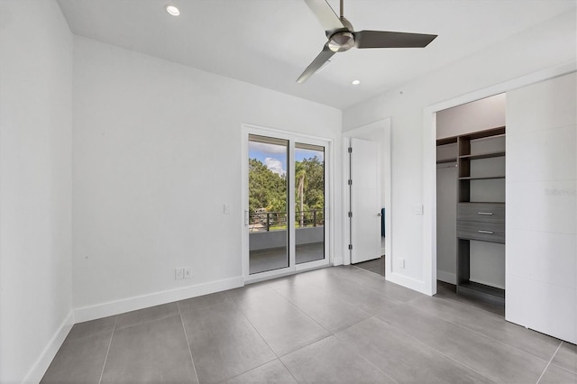 unfurnished bedroom featuring access to outside, a closet, a spacious closet, and ceiling fan