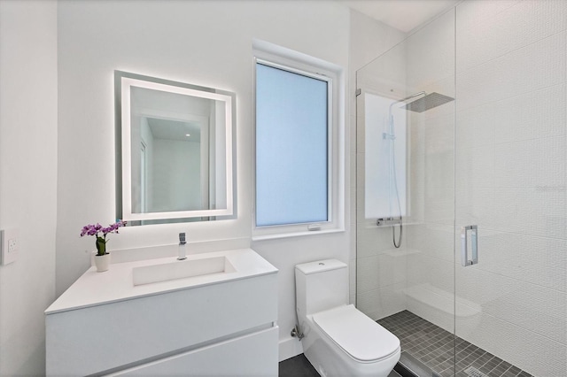 bathroom featuring vanity, toilet, and a shower with door