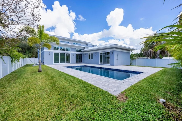 back of house featuring a yard, a fenced in pool, and a patio area