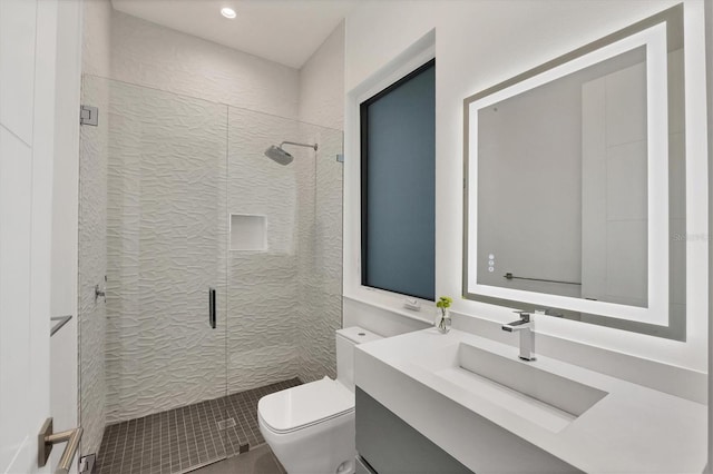 bathroom featuring vanity, toilet, and a shower with door