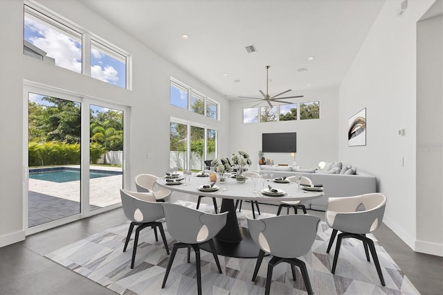 dining space with a towering ceiling, baseboards, visible vents, and recessed lighting