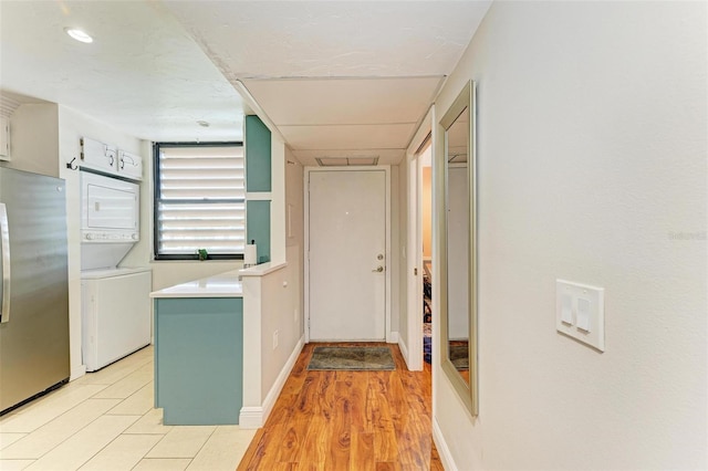 interior space with light hardwood / wood-style floors and stacked washer and clothes dryer