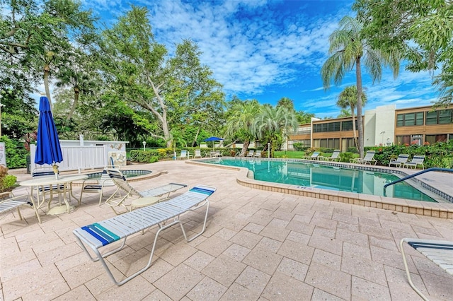 view of swimming pool with a jacuzzi and a patio