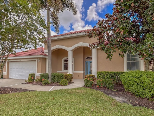 mediterranean / spanish house featuring a tile roof, driveway, an attached garage, and stucco siding