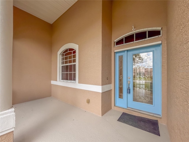 doorway to property featuring stucco siding