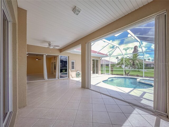 view of pool with ceiling fan, a patio, a lanai, and a pool with connected hot tub