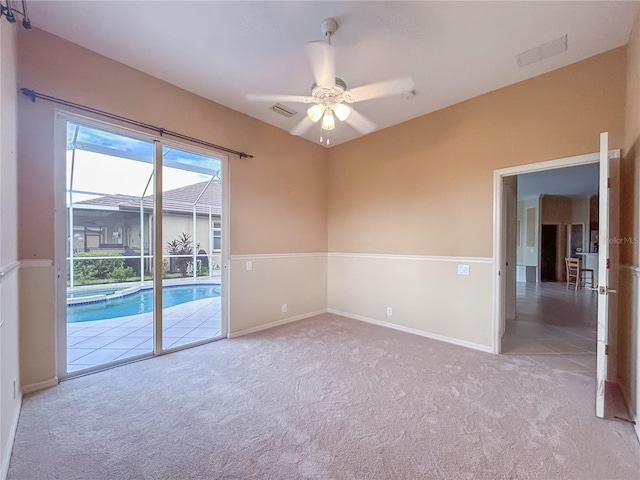 carpeted spare room with ceiling fan, visible vents, and baseboards