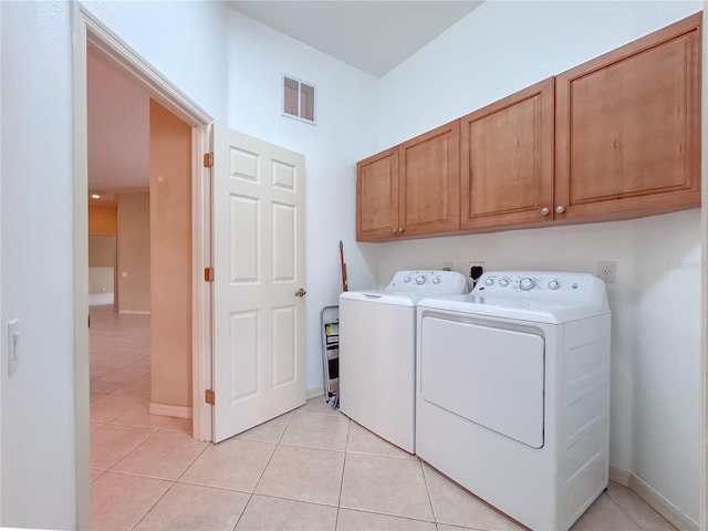 washroom featuring cabinet space, light tile patterned floors, baseboards, visible vents, and separate washer and dryer