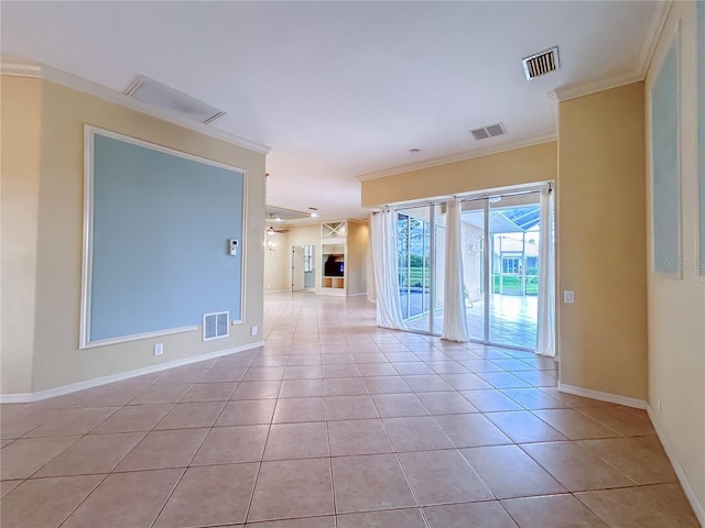 empty room with light tile patterned floors, visible vents, and crown molding