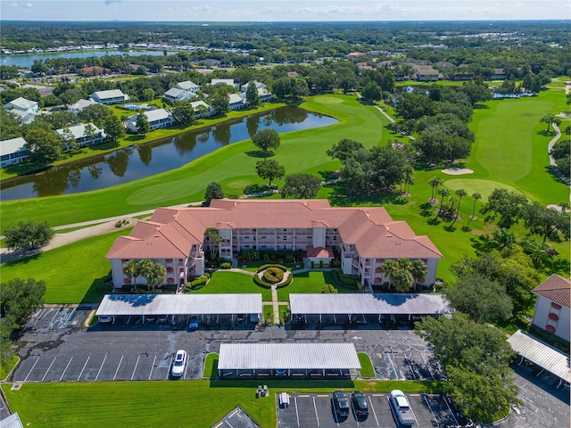 drone / aerial view with golf course view and a water view